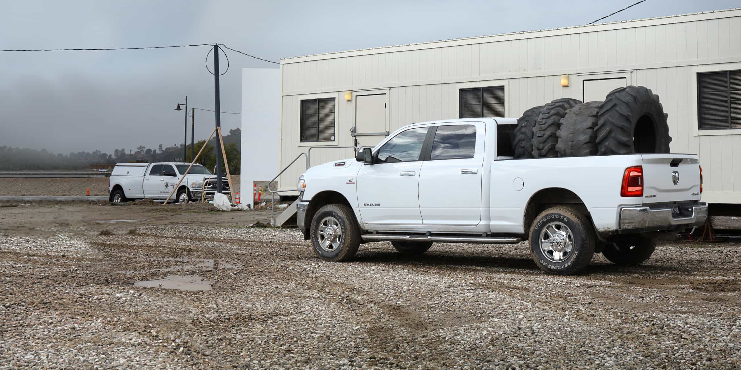 Una Ram 2500 2021 blanca con cuatro neumáticos extragrandes en su plataforma.
