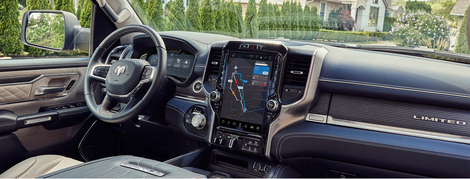 El interior de la Ram 1500 Limited Elite 2023 exhibiendo el volante y la pantalla táctil, que muestra un mapa de los alrededores del vehículo.