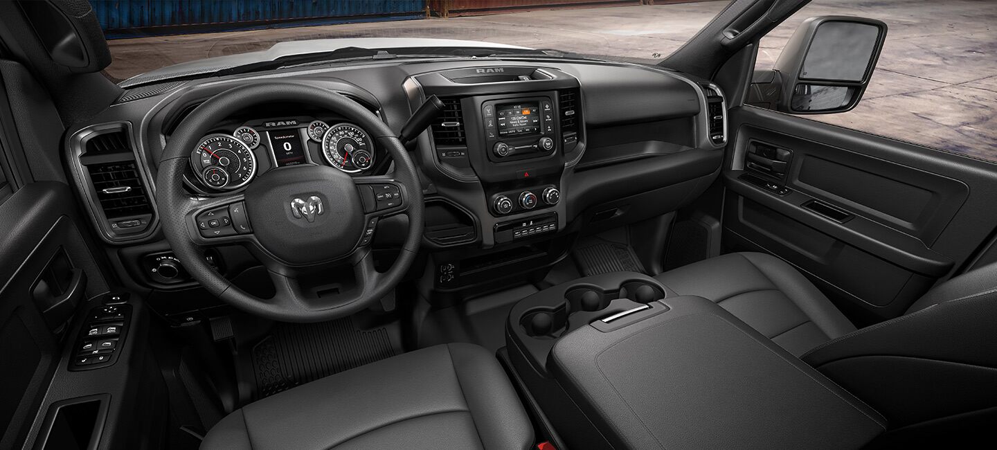 El interior de la Ram Tradesman Chassis Cab 2023 con el primero de los cuatro interiores con tapizado a elección, con la atención puesta en el volante, la pantalla táctil, los controles de la consola central, el tablero, los asientos delanteros y la propia consola central.