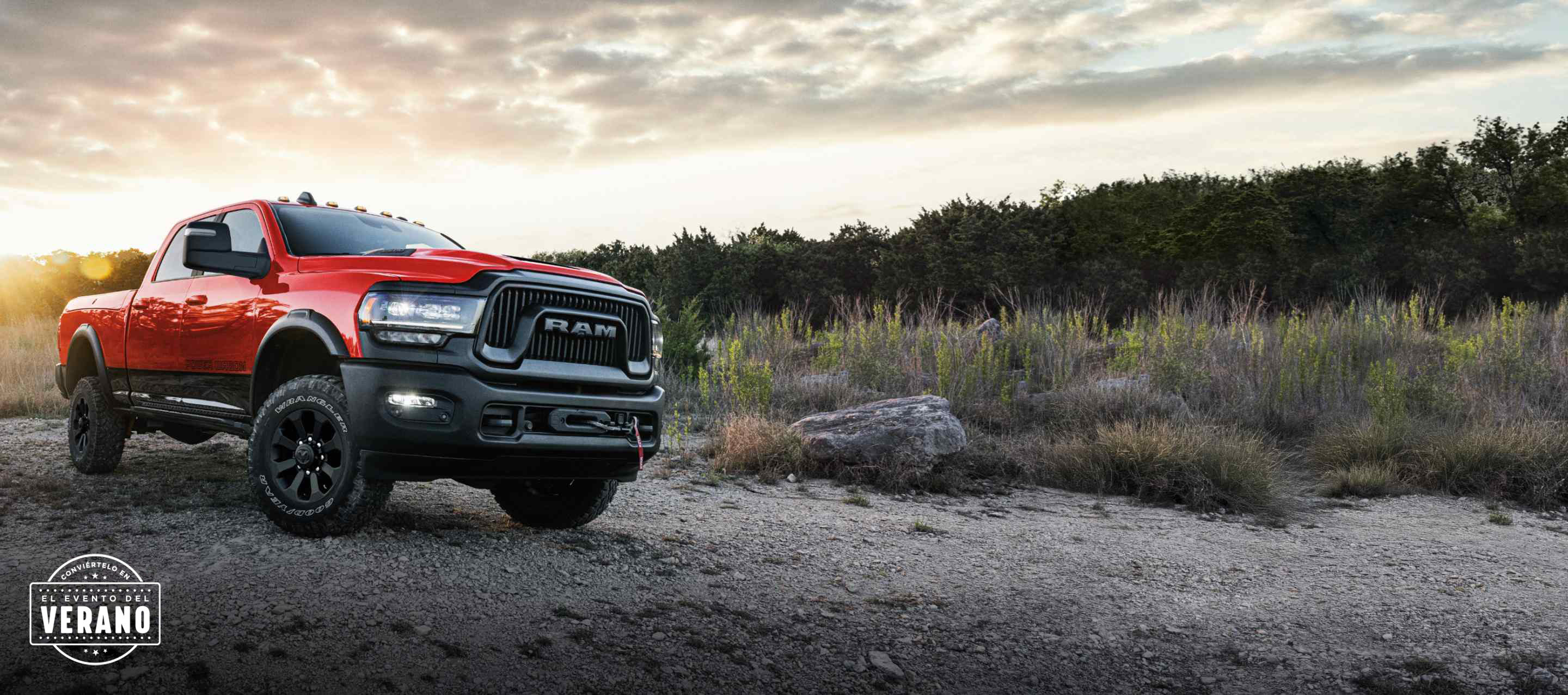 Una Ram 2500 Power Wagon 4x4 Crew Cab 2024 roja estacionada en un claro, fuera de la carretera, al atardecer. Conviértelo en el evento del verano.