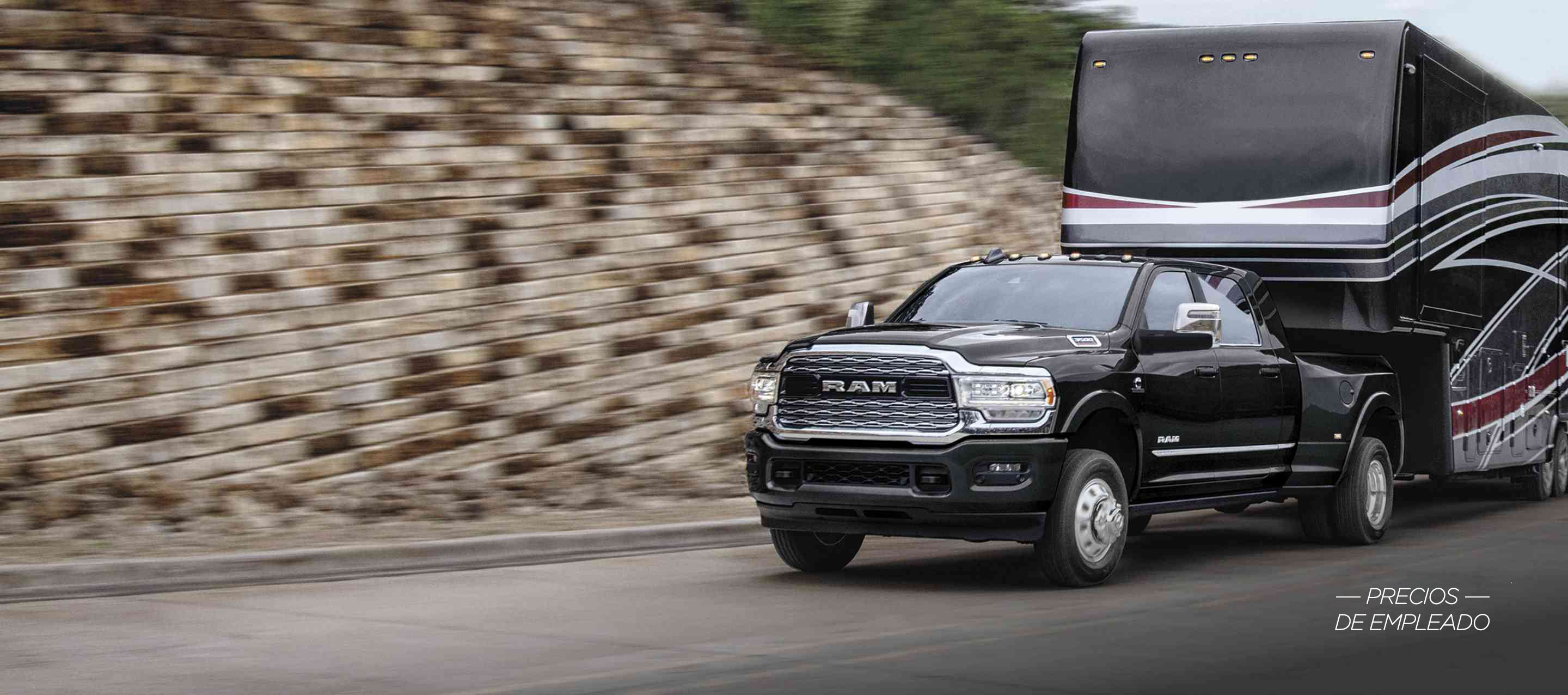Una Ram 3500 Limited Mega Cab 2024 negra circulando por una carretera, acarreando un gran remolque de viaje de quinta rueda. El fondo está borroso. Evento de ventas Precios de empleado.