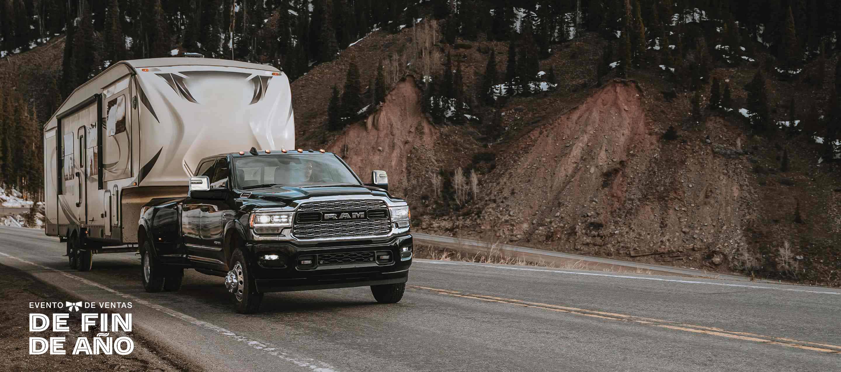 Una Ram 3500 Limited Crew Cab 2024 circulando por una carretera, acarreando un remolque de viaje de quinta rueda. El evento de ventas Fin de año.