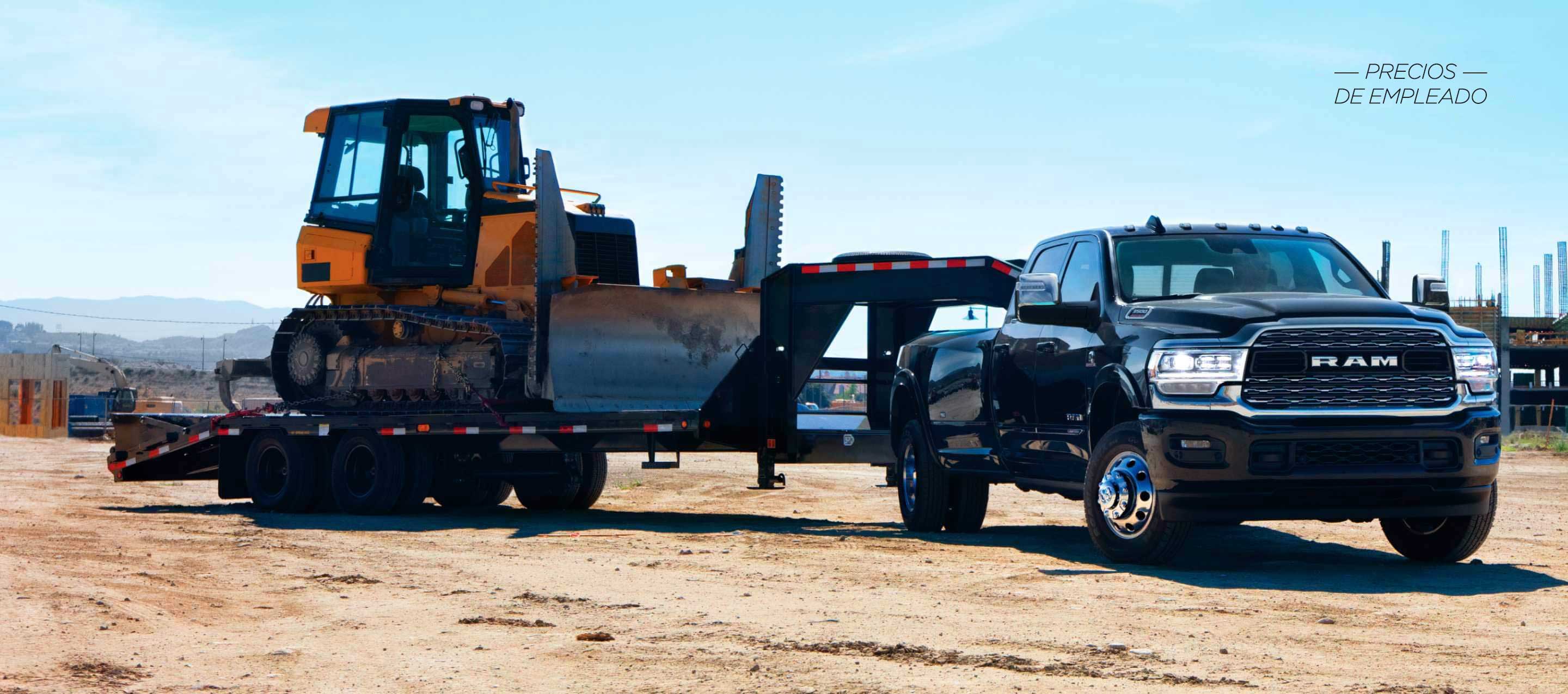 Una Ram 3500 Limited Crew Cab 2024 negra llevando un remolque de plataforma de quinta rueda con una excavadora. Evento de ventas Precios de empleado.