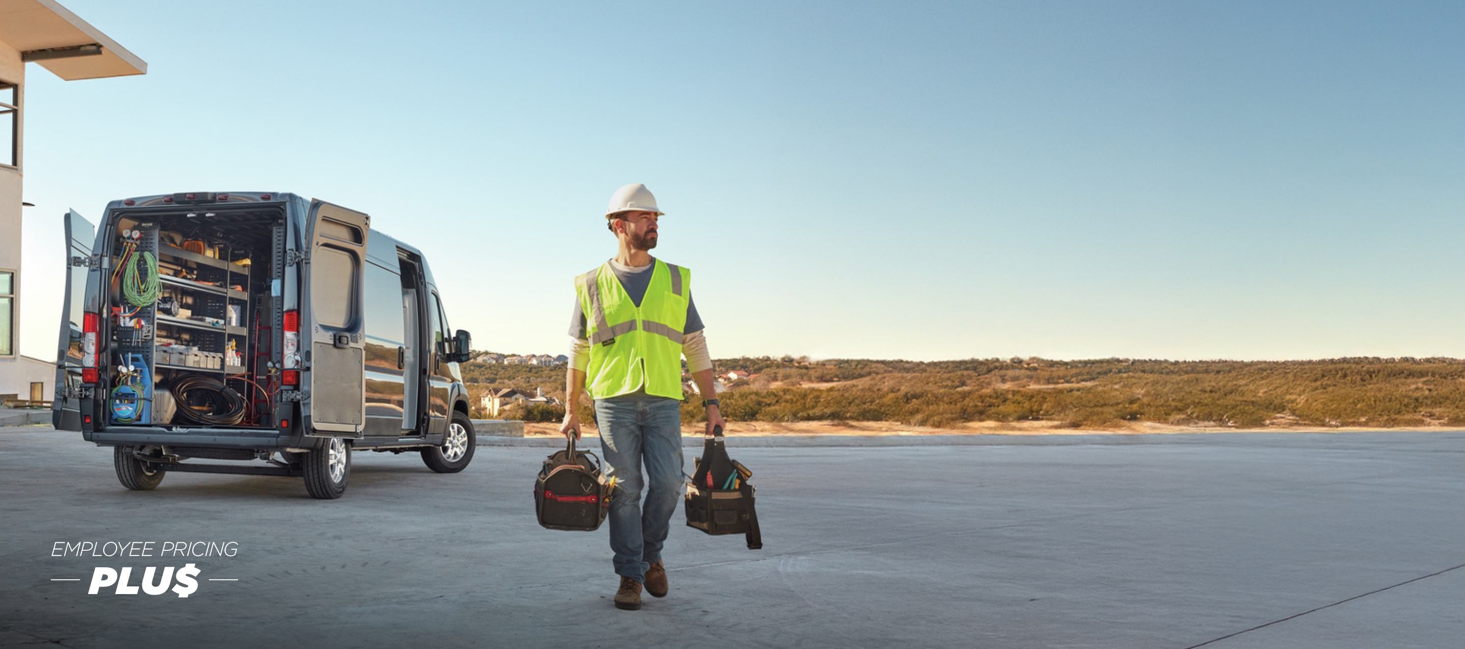 La parte trasera de una Ram ProMaster 3500 SLT Plus High Roof Cargo Van 2024 gris con la puerta corrediza del lado del pasajero y las puertas traseras abiertas, para exhibir estanterías llenas de herramientas y un técnico alejándose del vehículo. Evento de ventas Precios de empleado.