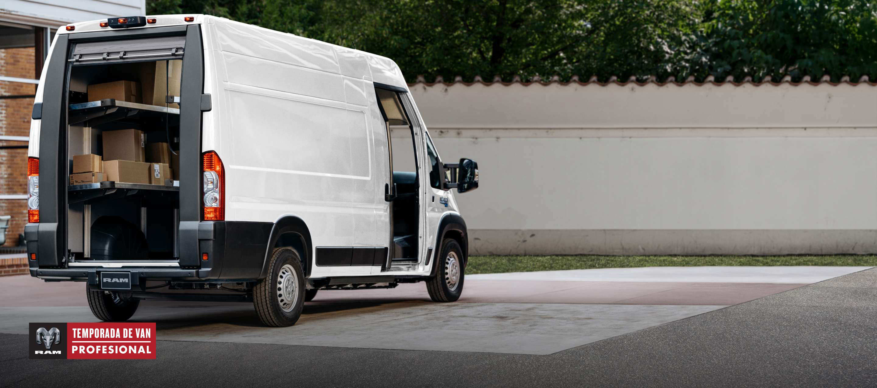 Ángulo trasero del lado del pasajero de una Ram ProMaster EV Step Van Super High Roof 2024 blanca con la puerta enrollable trasera levantada y la puerta lateral corrediza de pasajero abierta. Temporada de vans profesionales.