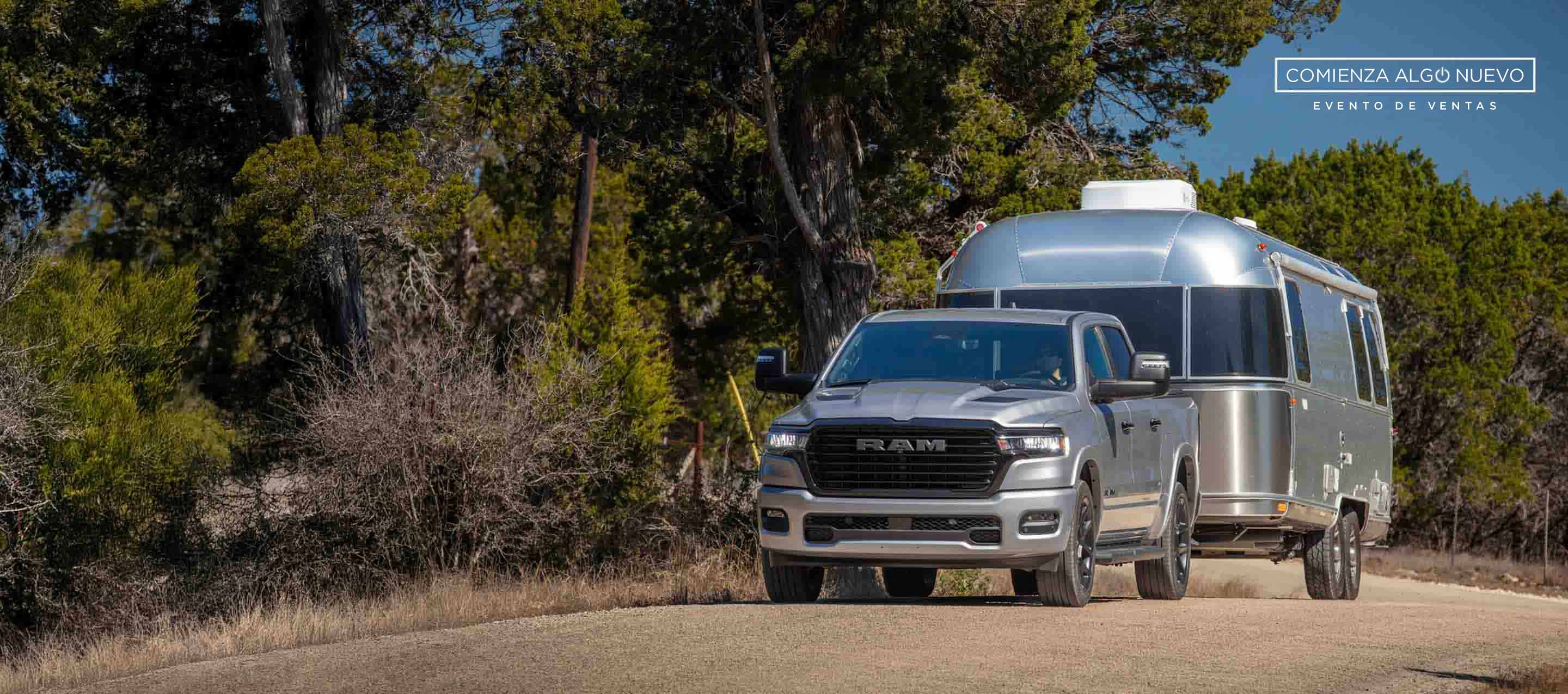 Una Ram 1500 Laramie Crew Cab 2025 llevando un remolque grande y circulando por una autopista. El evento de ventas “Comienza algo nuevo”.