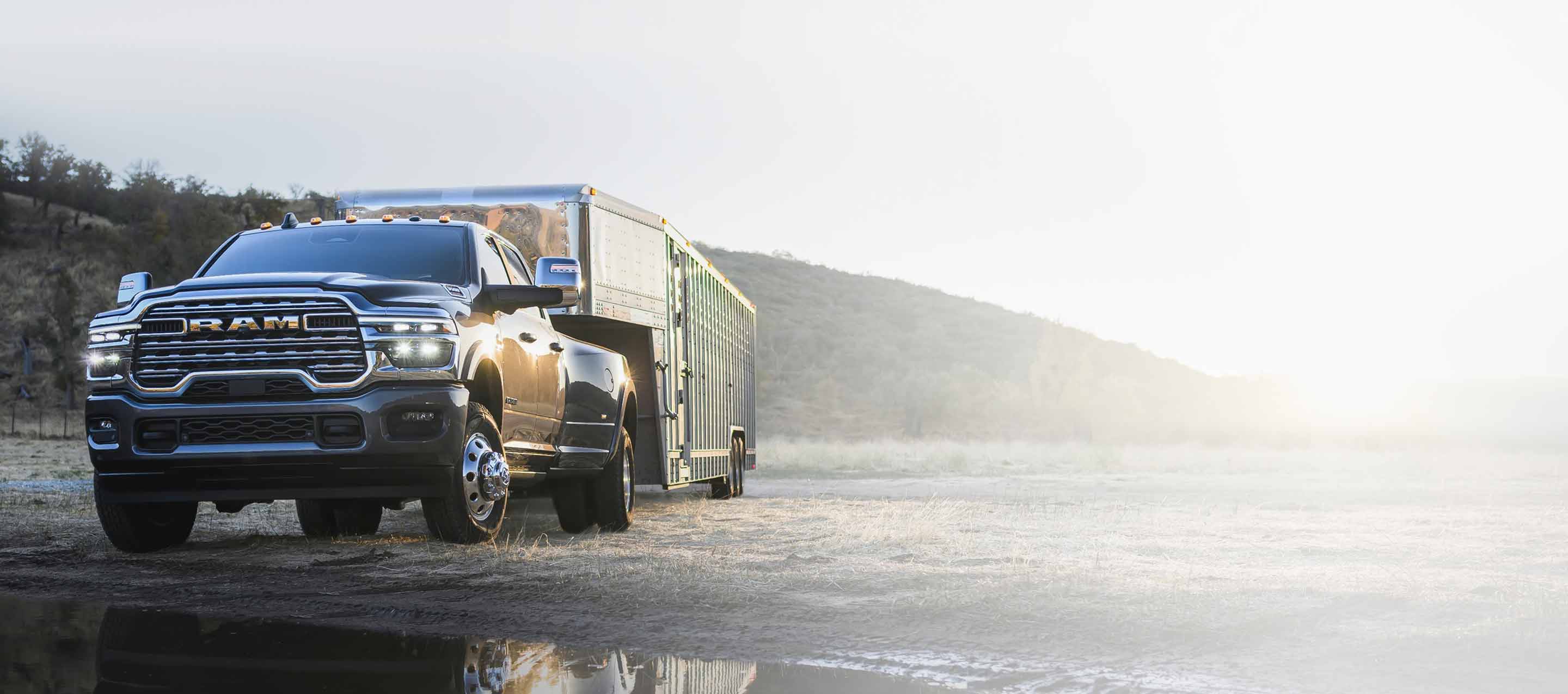 Una Ram 3500 Laramie 4x4 Crew Cab 2025 roja remolcando un contenedor cerrado.