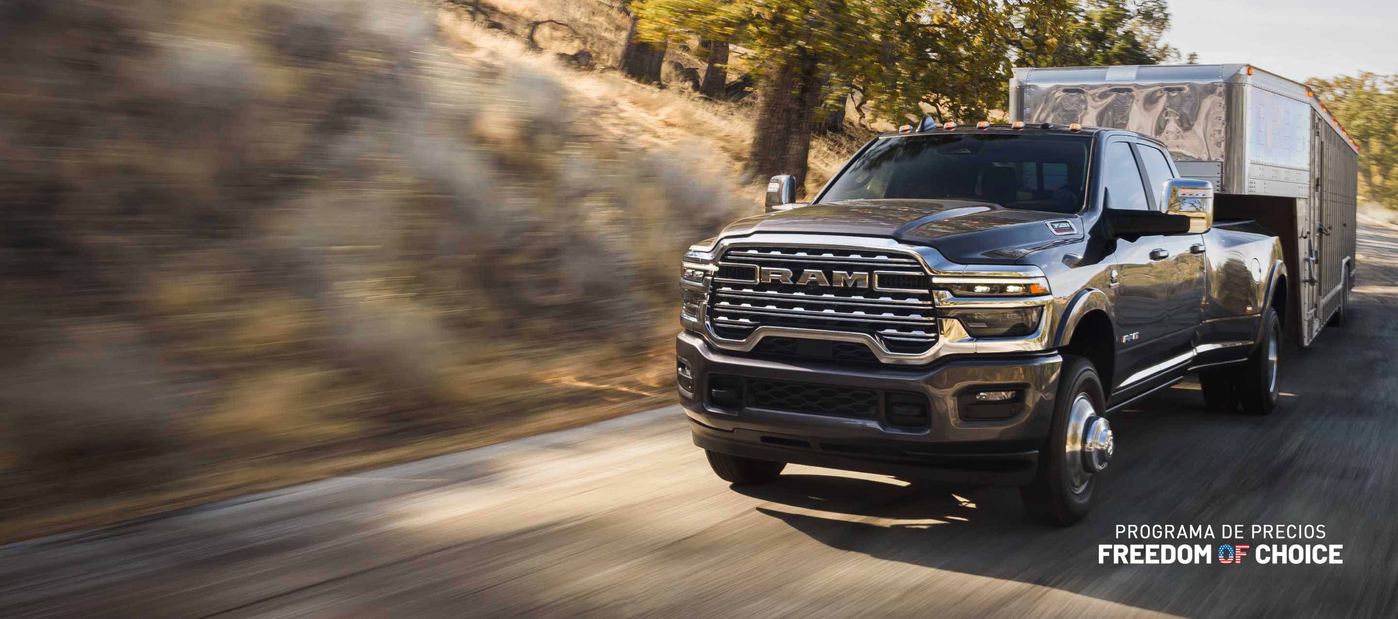 Una Ram 3500 Limited Longhorn 4x4 Crew Cab 2025 gris acarreando un remolque de quinta rueda grande para ganado. Evento de ventas de actualización de precios Freedom Of Choice.