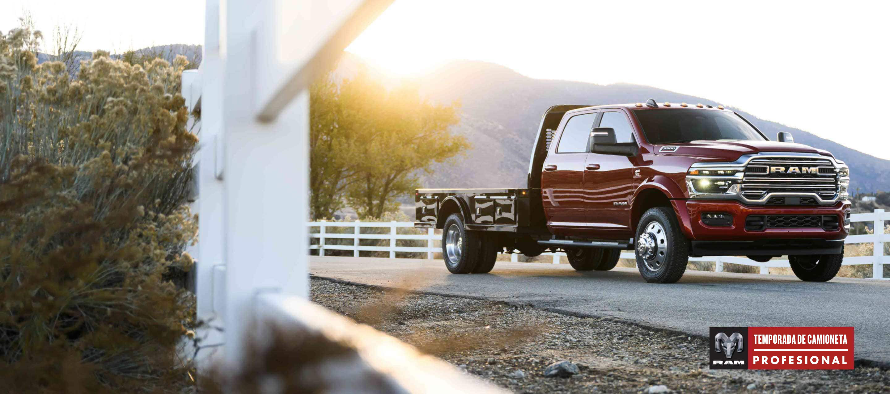 Una Ram 5500 Laramie Chassis Crew Cab 2025 roja con varios fardos de heno grandes amarrados en una mejora de plataforma larga. Evento de ventas Temporada de camionetas Ram Professional.