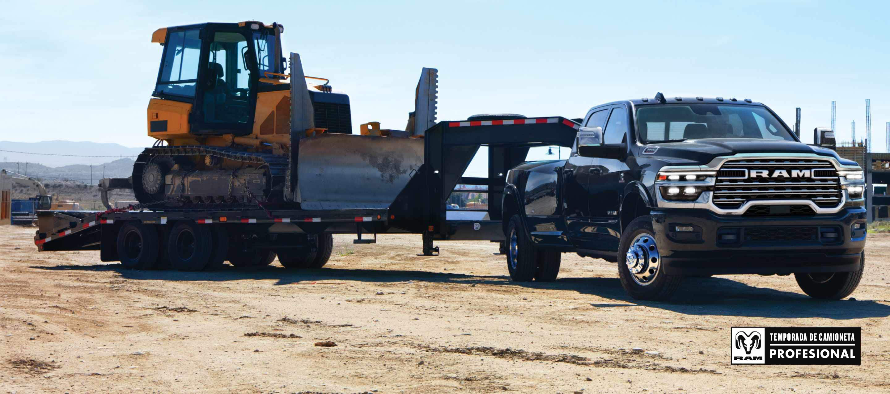Una Ram 3500 4x4 Crew Cab 2025 negra acarreando una excavadora con un remolque de plataforma plana de quinta rueda por una obra en construcción. Temporada de camionetas Ram Professional.