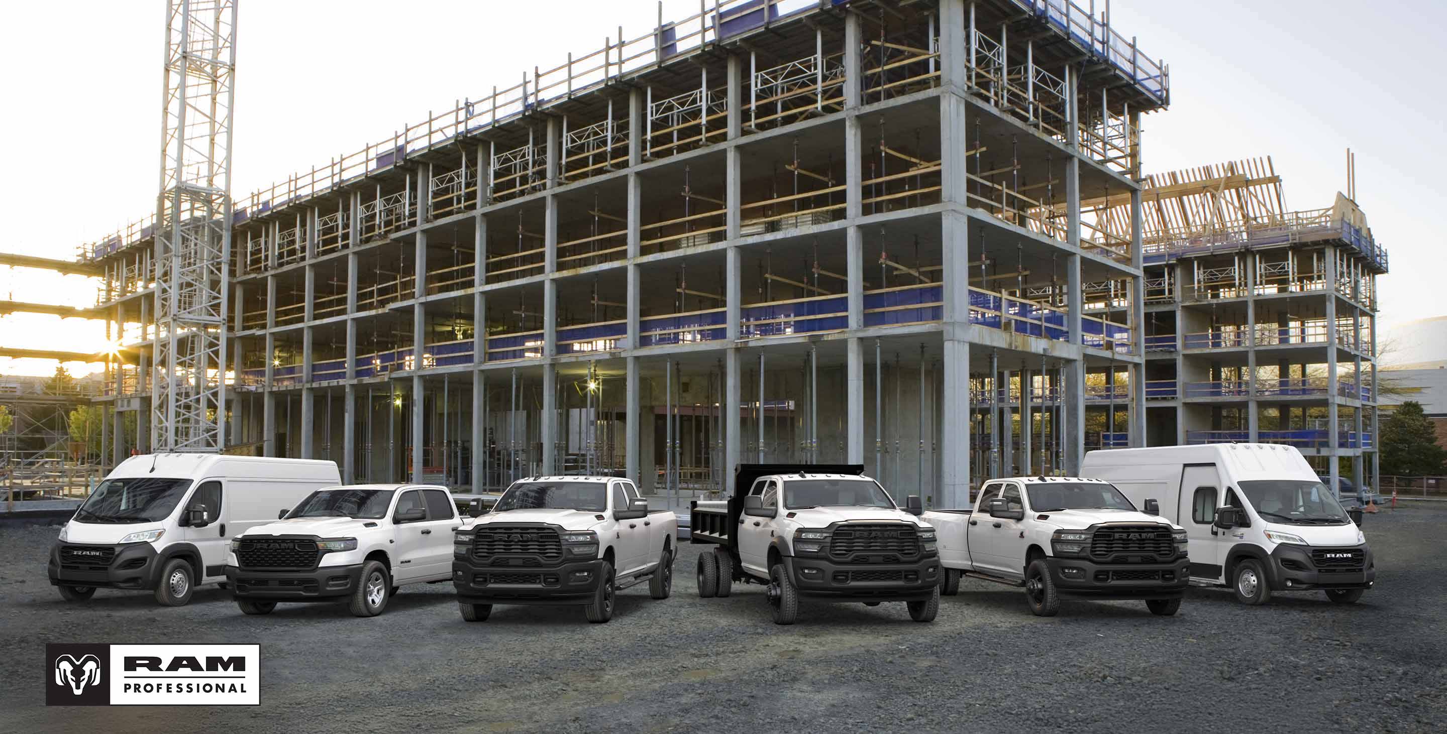 Ángulo delantero del lado del pasajero de una Ram ProMaster 1500 Tradesman Standard Roof Cargo Van 2025 blanca estacionada en una obra en construcción, con una escalera en la parrilla portaequipaje. Ram Professional.