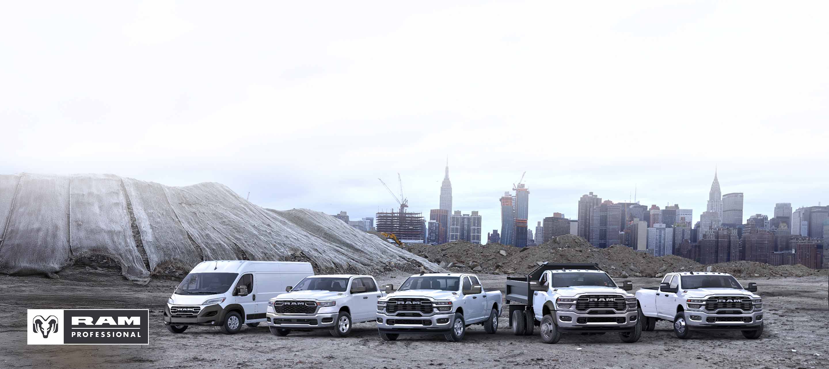 Línea de la marca Ram 2026 en blanco: una Ram ProMaster 3500 SLT Plus High Roof Cargo Van, una Ram 1500 Tradesman 4x4 Crew Cab, una Ram 2500 Tradesman 4x4 Crew Cab, una Ram 3500 Tradesman 4x2 Chassis Cab Regular Cab con mejora de carrocería volcadora y una Ram 3500 Tradesman 4x4 Crew Cab; todos los vehículos estacionados uno al lado del otro en una obra de construcción, con un paisaje urbano de fondo.