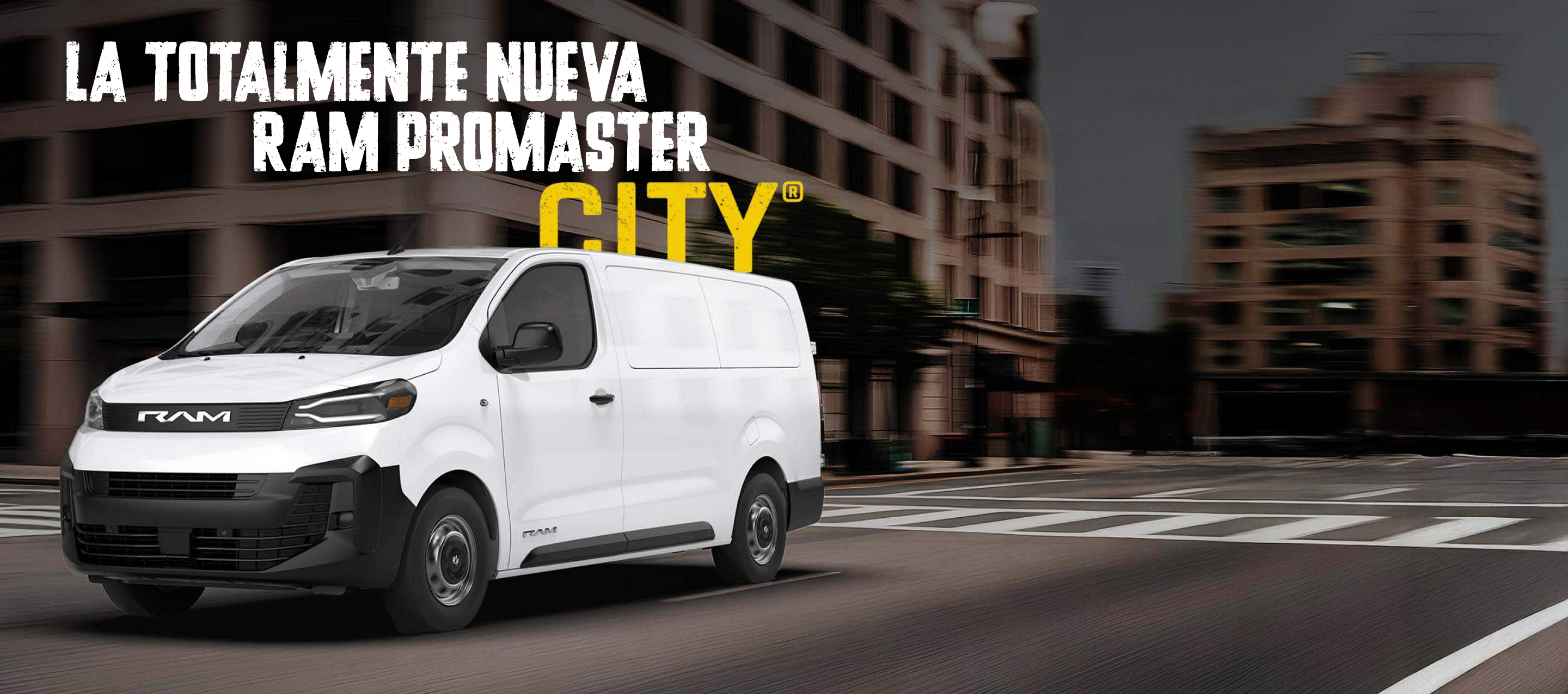 Una cargo van Ram ProMaster City Tradesman 2027 blanca circulando por una intersección en una calle de la ciudad. Nueva Ram ProMaster City.