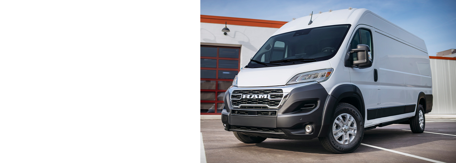 Una Cargo Van Ram ProMaster EV 3500 SLT High Roof 2025 blanca estacionada cerca de un garaje comercial.