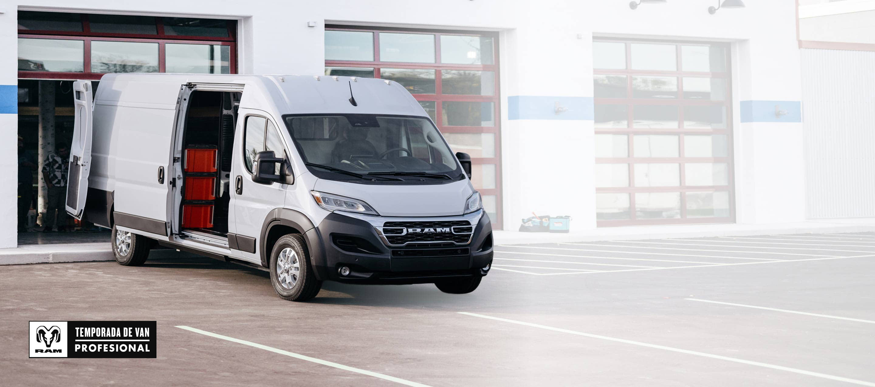 Una Ram ProMaster EV 3500 SLT Plus High Roof Cargo Van 2025 con la puerta corrediza del lado de los pasajeros y las puertas traseras abiertas, donde se observan cajas en estantes. Temporada de vans profesionales Ram.