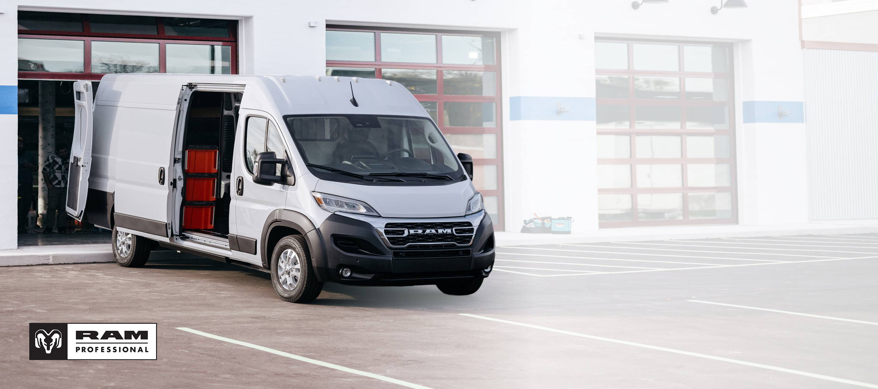 Una Ram ProMaster EV 3500 SLT Plus High Roof Cargo Van 2025 con la puerta corrediza del lado de los pasajeros y las puertas traseras abiertas, donde se observan cajas en estantes. Ram Professional.