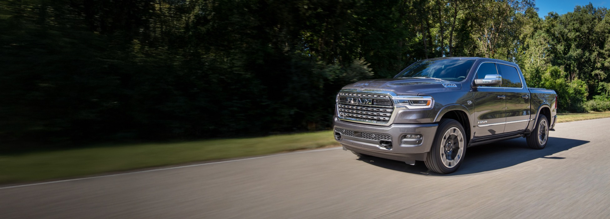 Una Ram 1500 Limited 4x4 Crew Cab 2026 gris circulando por un camino campestre.