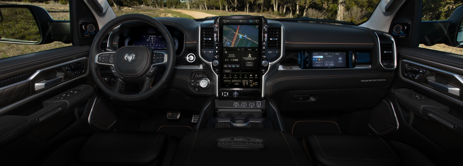 El área del asiento delantero de la Ram 1500 Tungsten 2026, en la que se destaca el volante, el panel de instrumentos digital, la pantalla táctil Uconnect y la pantalla interactiva del pasajero delantero.