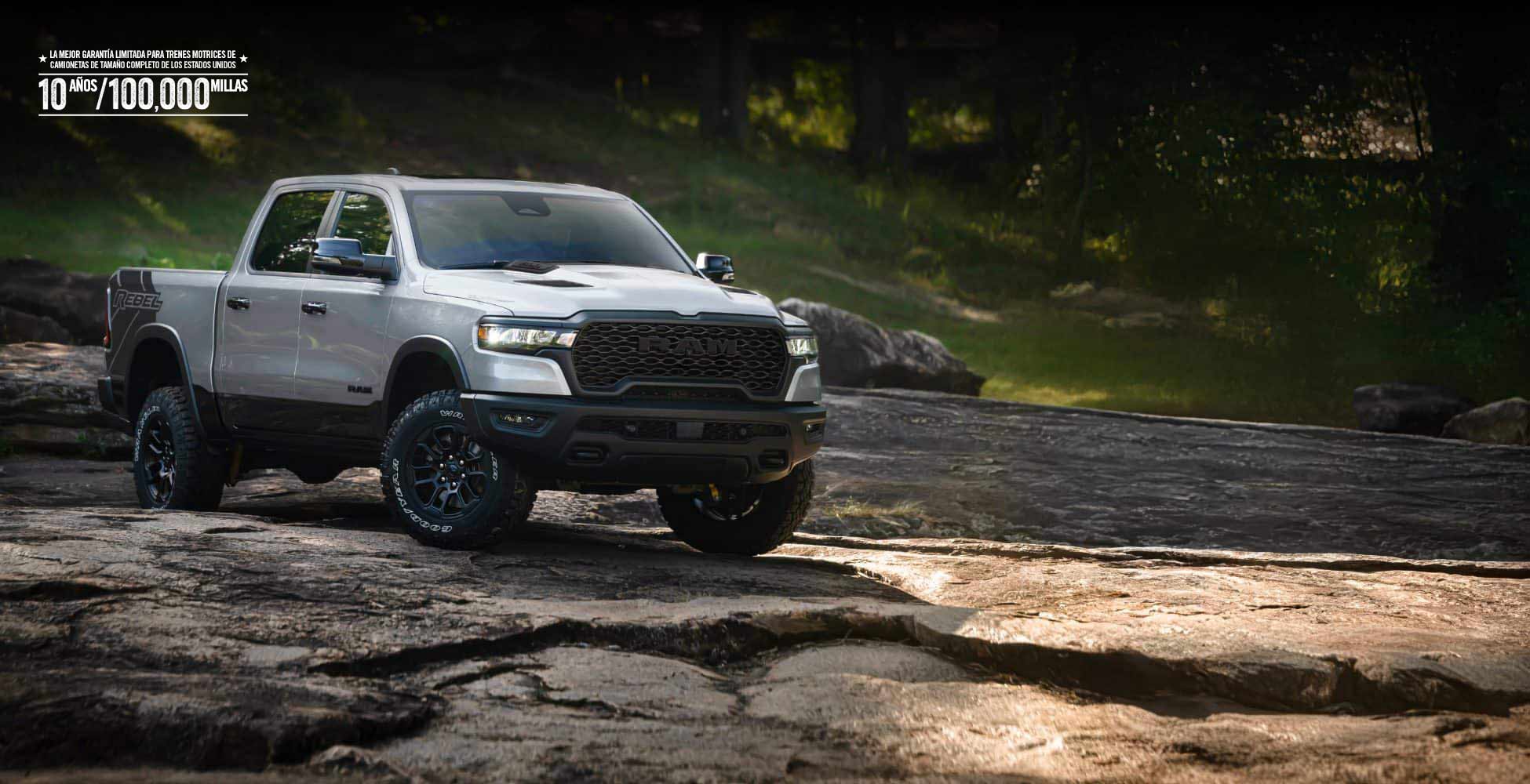 Una Ram 1500 Rebel 4x4 Crew Cab 2026 plateada recorriendo un sendero irregular fuera de carretera. La mejor garantía limitada del tren motriz para camionetas de tamaño completo de los Estados Unidos, de 10 años/100,000 millas.