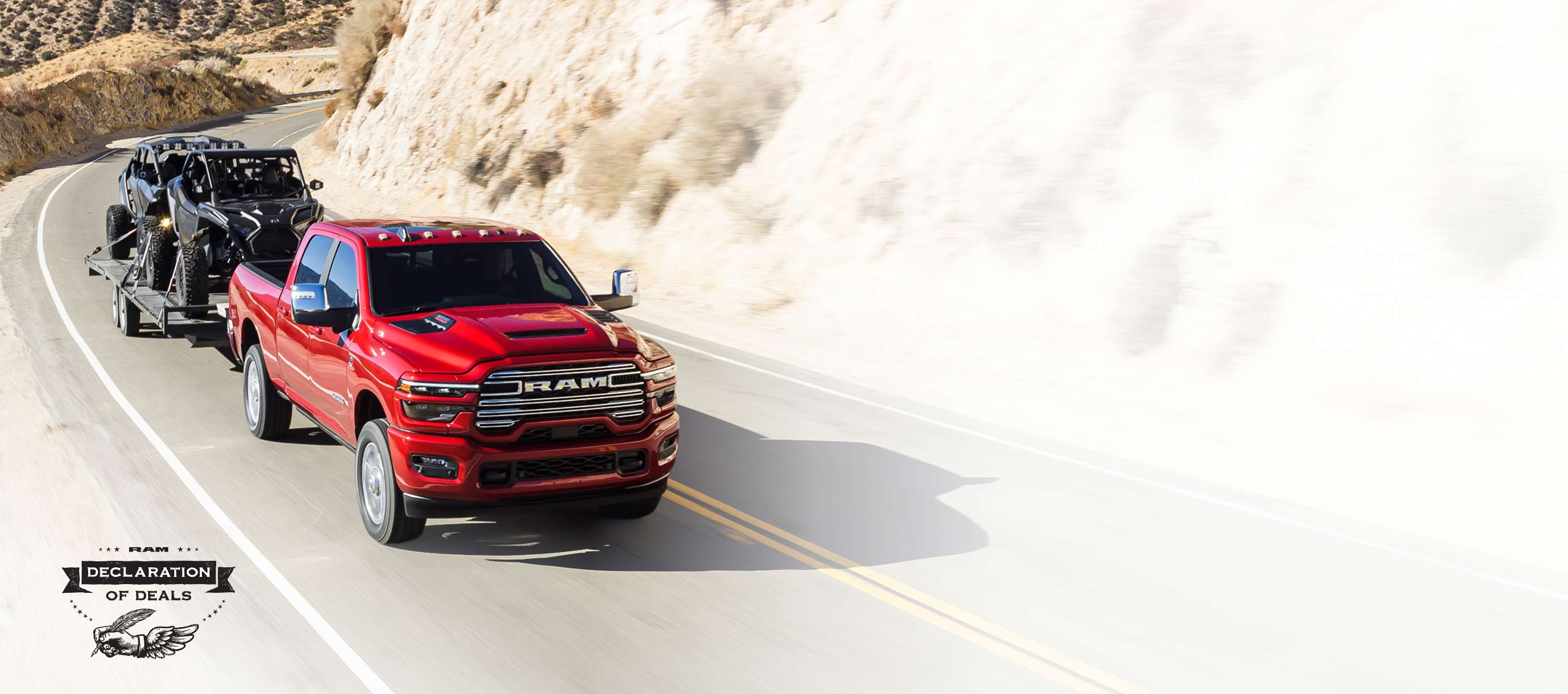 Una Ram 2500 Laramie 4x4 Crew Cab 2026 roja circulando por una carretera en las montañas, mientras remolca dos ATV. Evento de ventas Declaración de ofertas.