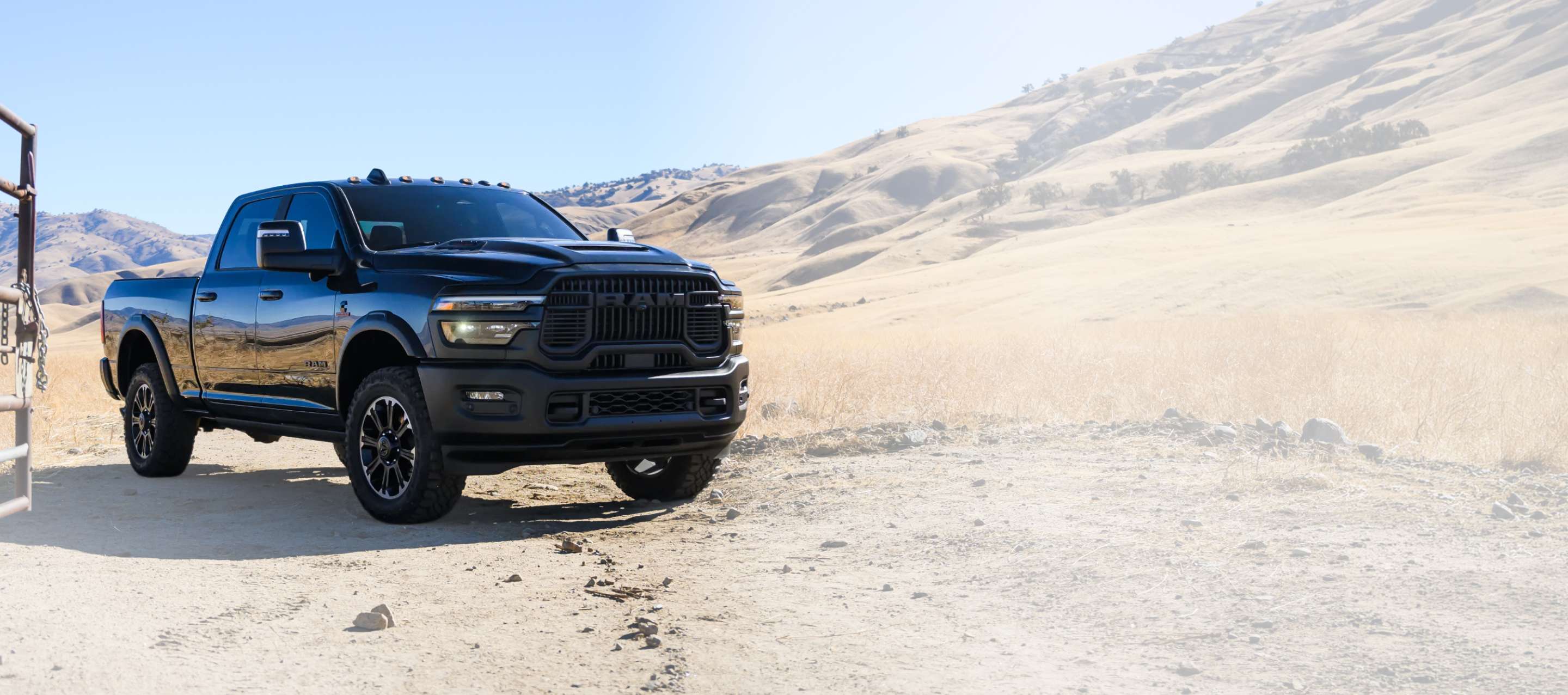 Una Ram 2500 Rebel 4x4 Crew Cab 2026 negra estacionada en un rancho en el desierto. Evento de ventas del Día del Trabajo y 10 años/100000 millas.