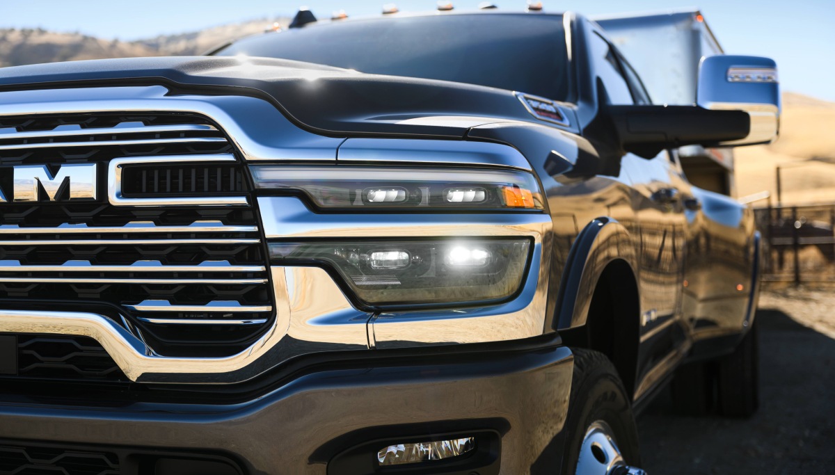 Se muestran una parte de la parrilla y el faro delantero del lado del conductor en una Ram 3500 Limited Longhorn 2026 negra.