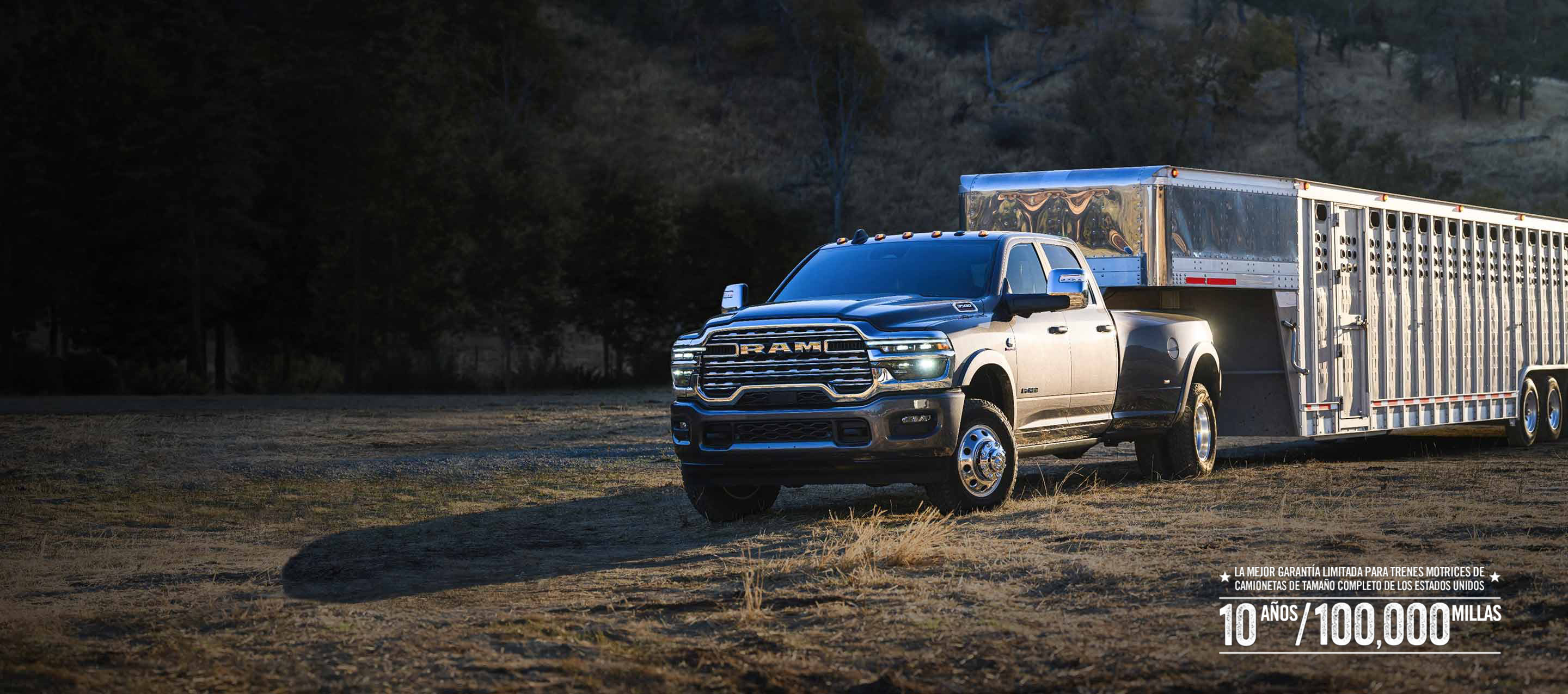 Una Ram 3500 Limited Longhorn 4x4 Crew Cab 2026 gris lleva un gran remolque ganadero de quinta rueda mientras circula fuera de carretera. Garantía limitada de 10 años/100,000 millas.
