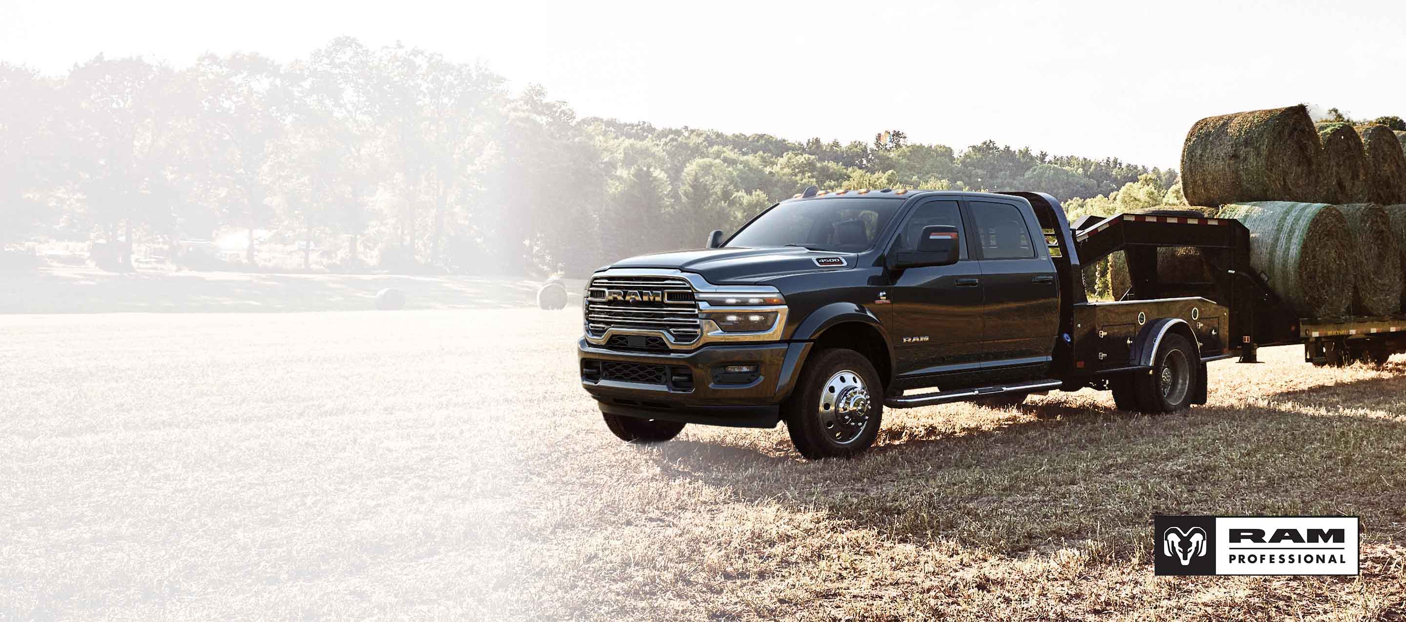 Una Ram 2500 Limited Crew Cab 2026 negra con una pala de nieve circula por un sendero cubierto de nieve en las montañas. Ram Professional.