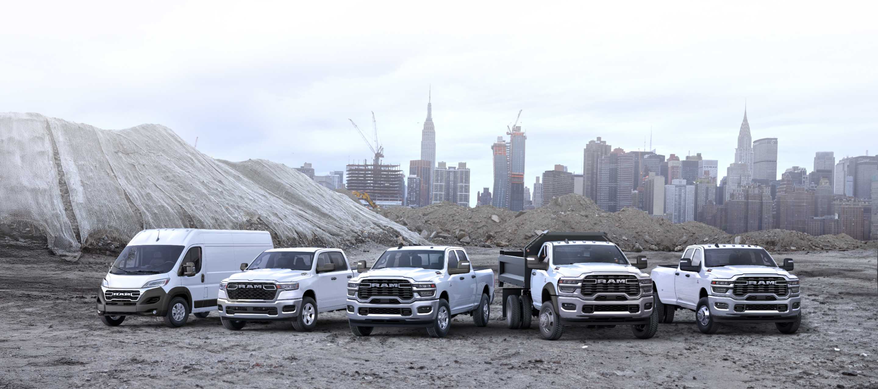 Una fila de camionetas y vans Ram, todas blancas, en un sitio de construcción comercial. De izquierda a derecha: una cargo van Ram ProMaster 3500 SLT High Roof, una Ram 1500 Tradesman 4x4 Crew Cab, una Ram 2500 Tradesman 4x4 Crew Cab, una Ram 4500 Chassis Cab Big Horn Regular Cab con una mejora de carrocería volcadora y una Ram 3500 Tradesman 4x4 Crew Cab. Ram Professional.