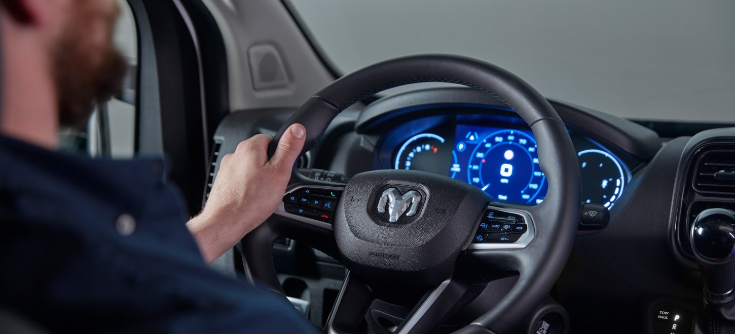 Se muestra el interior de la Ram ProMaster 2026 con el foco puesto en el volante y la pantalla digital en el panel de instrumentos.