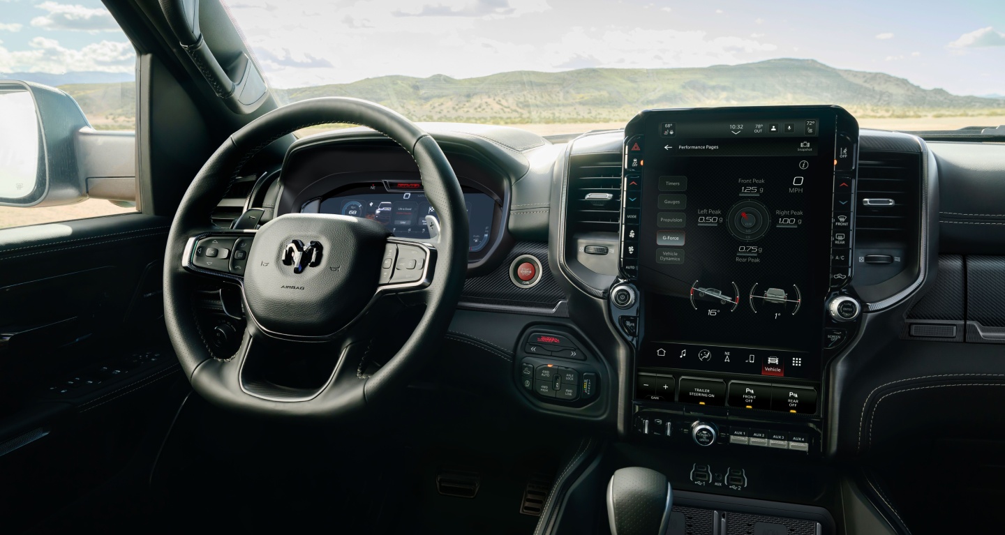 Muestra El volante, la pantalla digital del panel de instrumentos, la pantalla táctil Uconnect y los controles de la consola central de la Ram 1500 RHO 4x4 Crew Cab 2027.