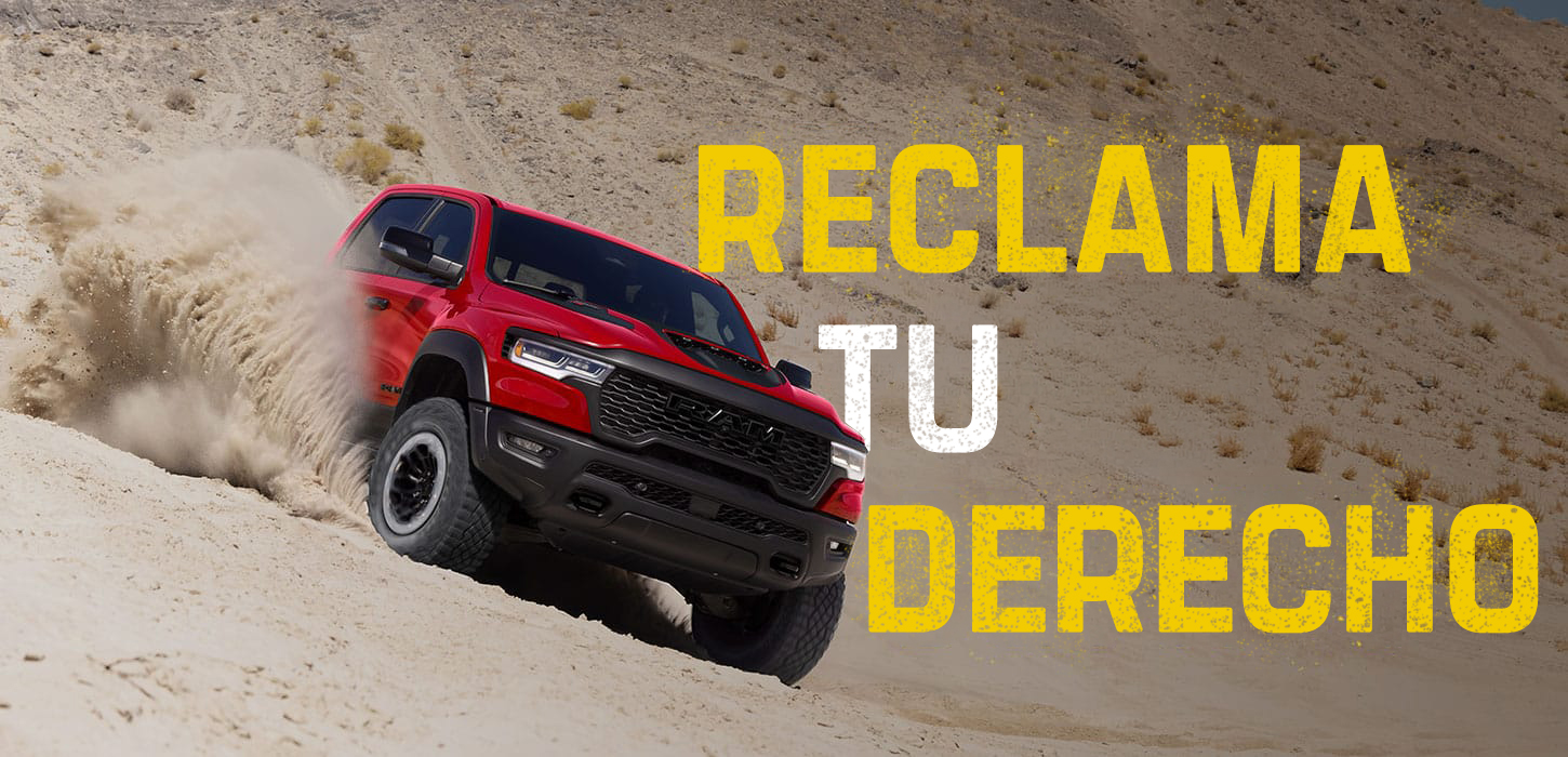 Una Ram 1500 RHO 4x4 Crew Cab 2027 roja, fotografiada mientras desciende una duna en ángulo, levantando arena a su paso. Reclama tu derecho.