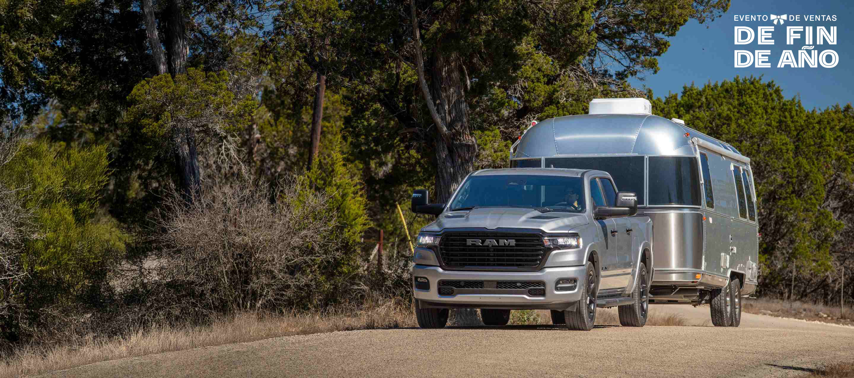 Una Ram 1500 Laramie Crew Cab 2025 llevando un remolque grande y circulando por una autopista. El evento de ventas Fin de año.