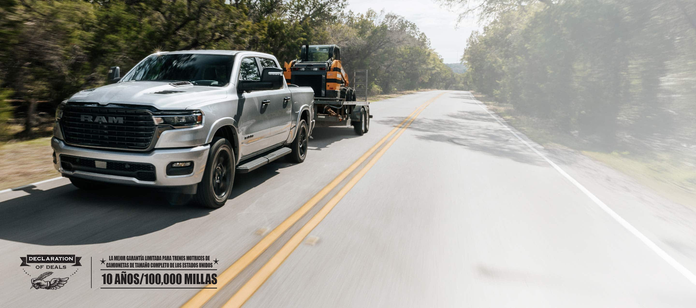 Una Ram 1500 Laramie 4x4 Crew Cab 2026 plateada circulando por una carretera, remolcando una excavadora sobre una minicargadora. Garantía limitada de 10 años/100,000 millas. Evento de ventas Declaración de ofertas.