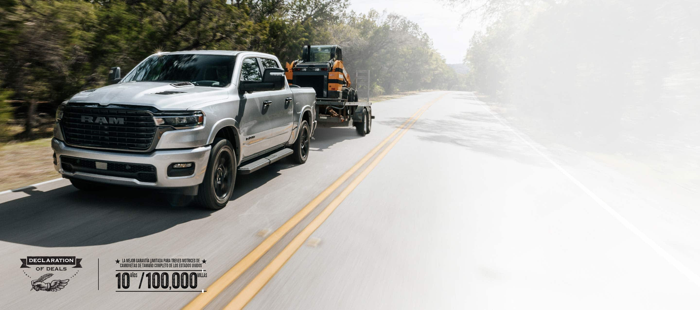 Una Ram 1500 Laramie 4x4 Crew Cab 2026 plateada circulando por una carretera, remolcando una excavadora sobre una minicargadora. Garantía limitada de 10 años/100,000 millas. Evento de ventas Declaración de ofertas.