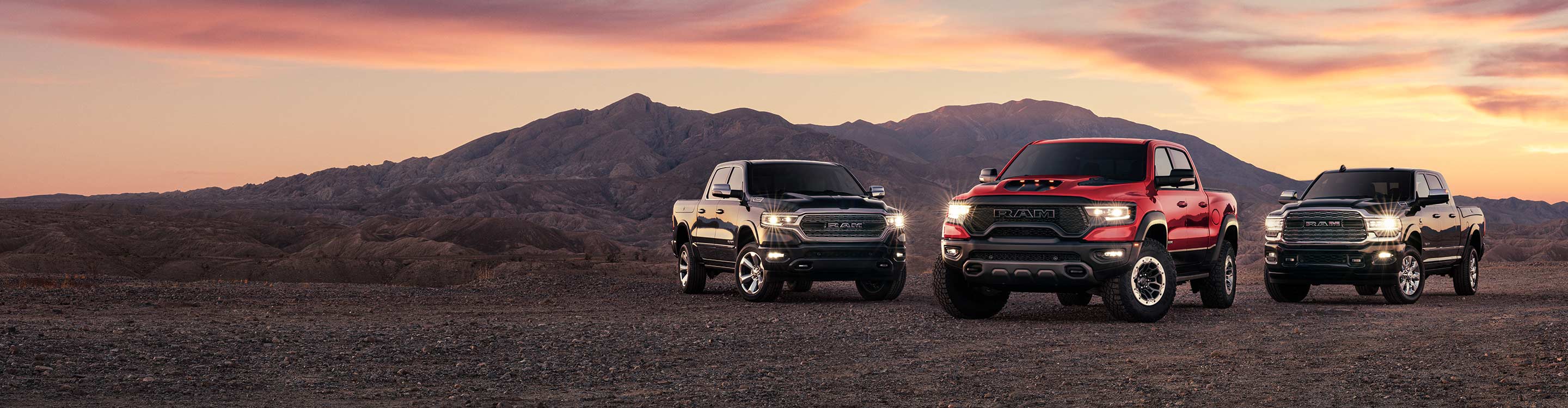 Logo de Ram ganadora por tercera vez, camioneta del año 2019, 2020, 2021 de MotorTrend y tres camionetas Ram 2021 estacionadas en un camino de montaña, una Ram 1500 Limited, una Ram 1500 TRX y una Ram 2500 Limited.