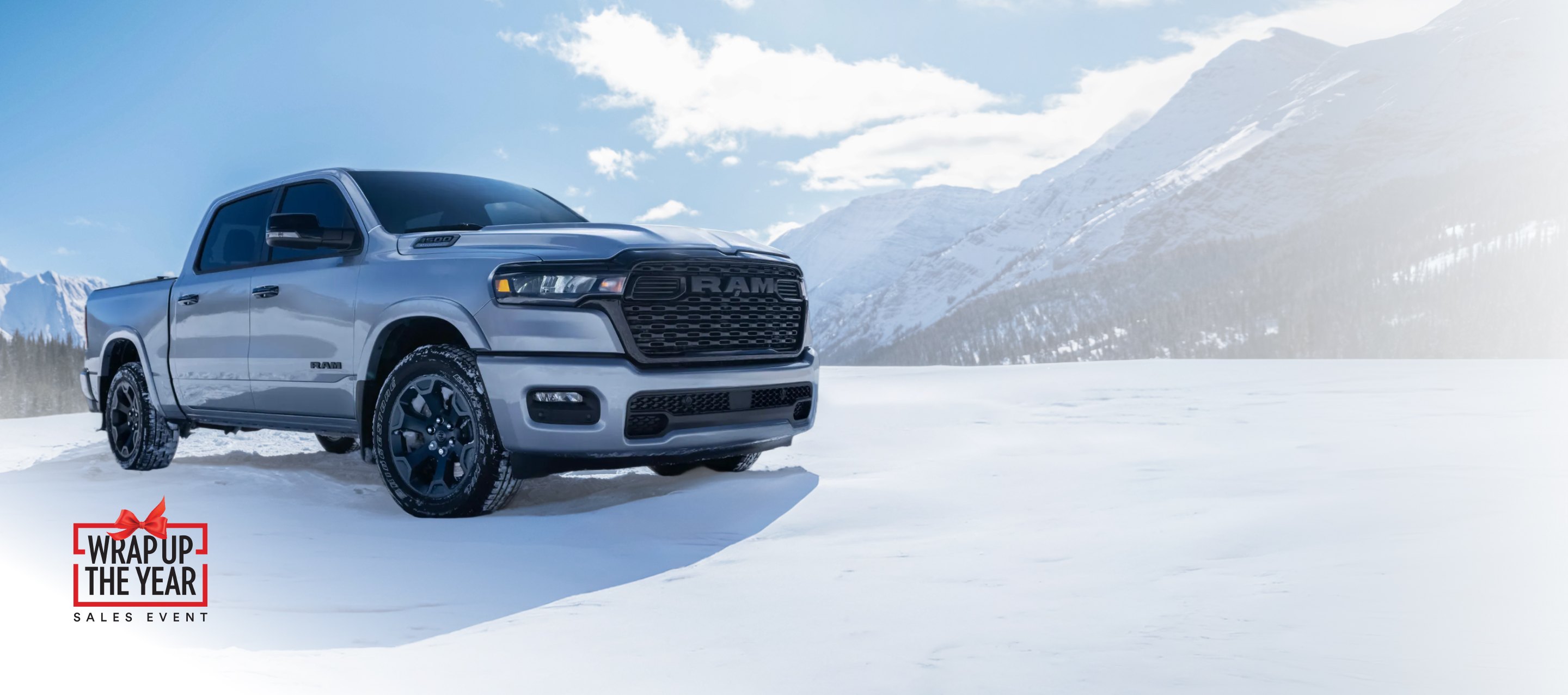 Una Ram 1500 Big Horn 4x4 Crew Cab 2026 blanca estacionada en un claro cubierto de nieve fuera de la carretera, en las montañas. Garantía limitada de 10 años/100,000 millas.