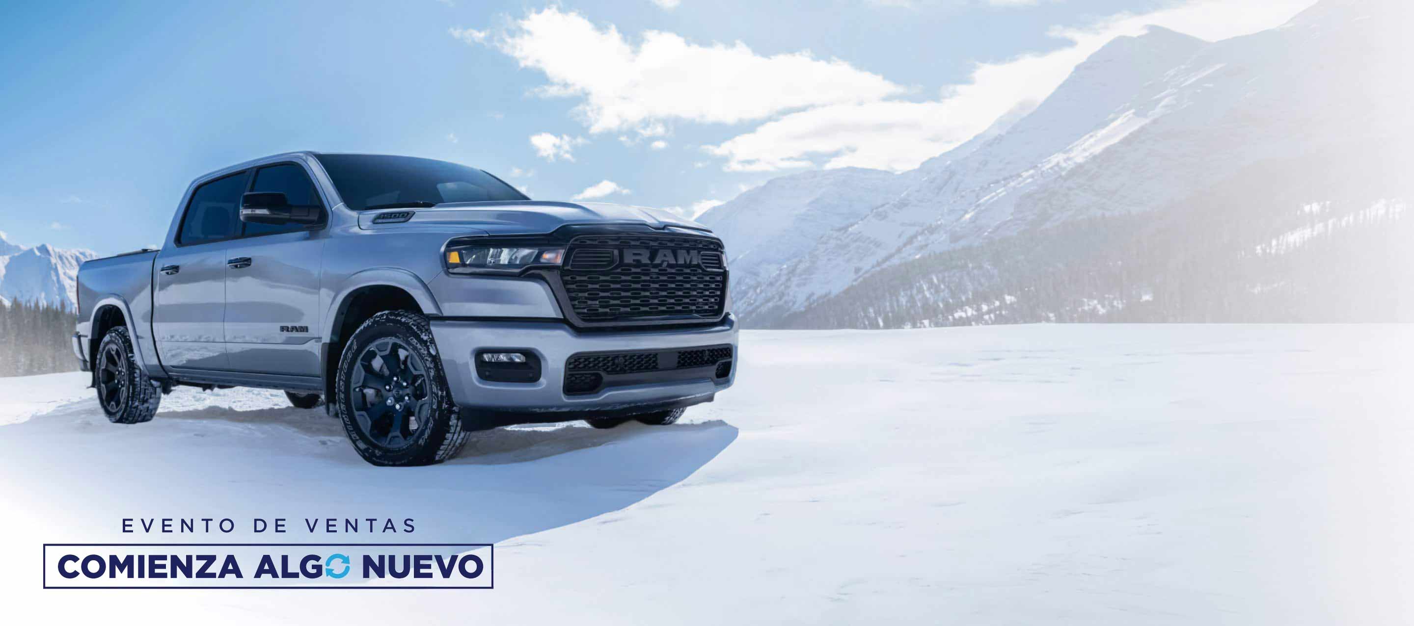Una Ram 1500 Big Horn 4x4 Crew Cab 2026 blanca estacionada en un claro cubierto de nieve fuera de la carretera, en las montañas. Evento de ventas “Comienza algo nuevo”.