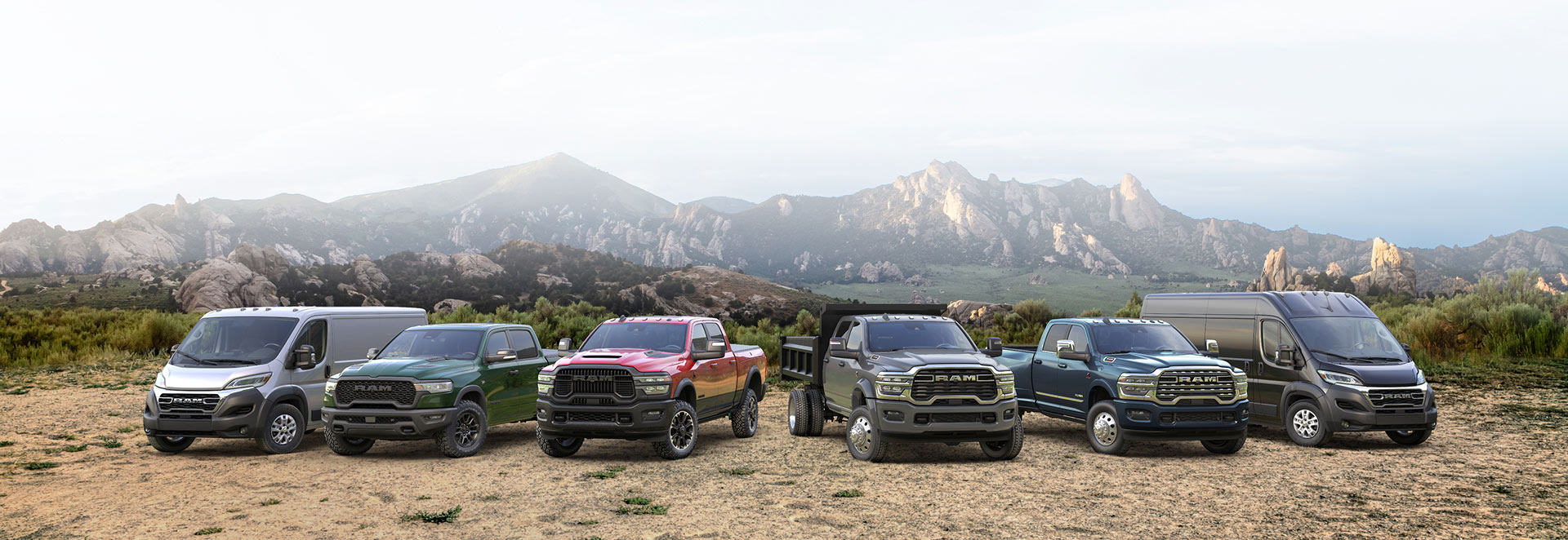 La línea Ram 2026: una Ram ProMaster 2500 SLT Standard Roof Cargo Van blanca, una Ram 1500 Rebel 4x4 Crew Cab verde, una Ram 2500 Rebel 4x4 Crew Cab roja, una Ram 4500 Big Horn Chassis Cab Crew Cab con mejora de carrocería volcadora ​​​​​​​gris, una Ram 3500 Limited 4x4 Crew Cab azul y una Ram ProMaster 3500 SLT Plus High Roof Cargo Van negra; todas estacionadas una al lado del otra en la cima de una colina.