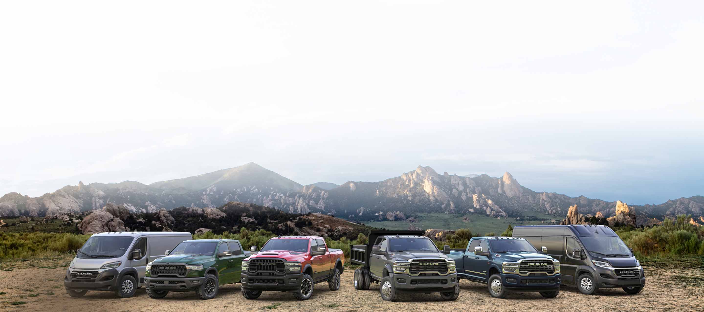 La línea Ram 2026: una Ram ProMaster 2500 SLT Standard Roof Cargo Van blanca, una Ram 1500 Rebel 4x4 Crew Cab verde, una Ram 2500 Rebel 4x4 Crew Cab roja, una Ram 4500 Big Horn Chassis Cab Crew Cab con mejora de carrocería volcadora gris, una Ram 3500 Limited 4x4 Crew Cab azul y una Ram ProMaster 3500 SLT Plus High Roof Cargo Van negra; todas estacionadas una al lado del otra en la cima de una colina.