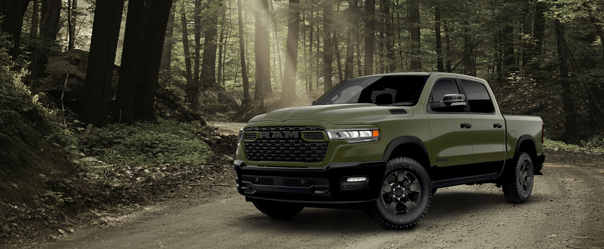 An olive green Ram 1500 BackCountry 4x4 Crew Cab pickup on a dirt road in the woods.