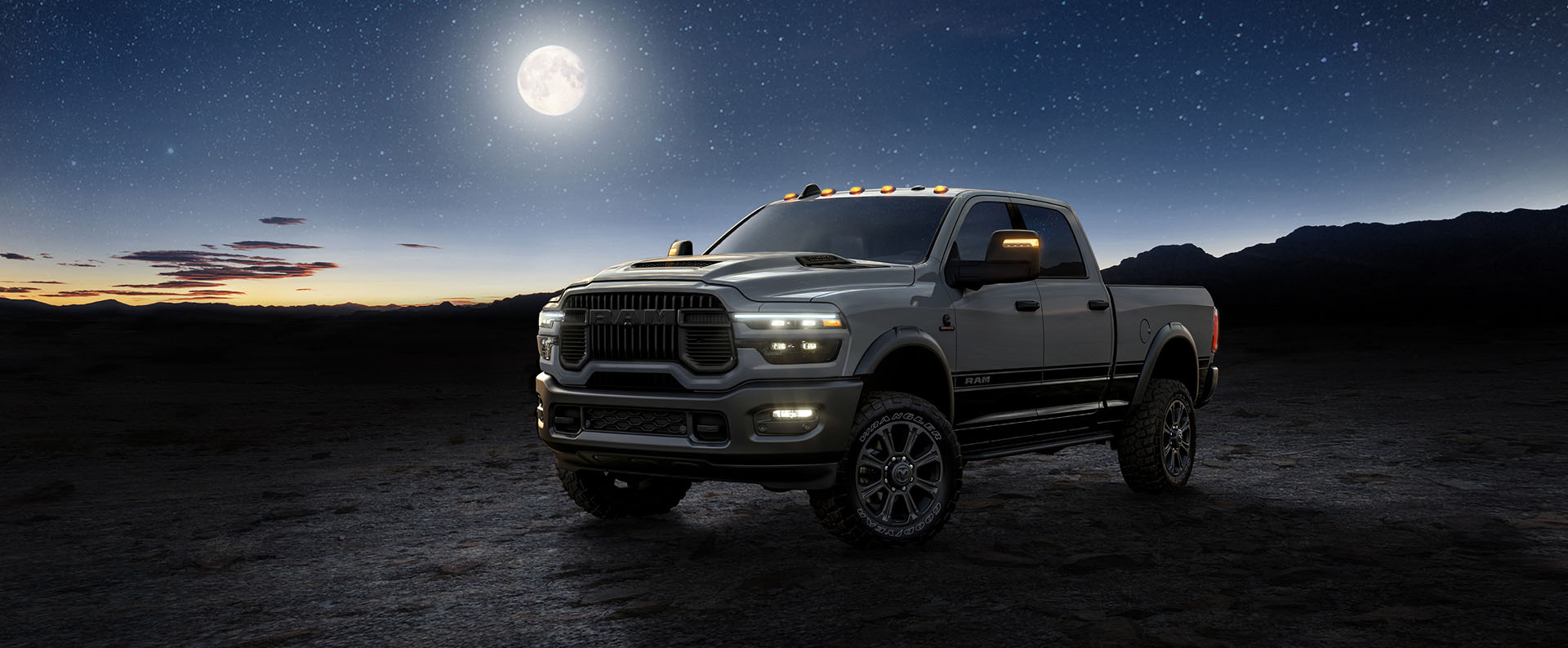 A light gray 2026 Ram 2500 Lunar 4x4 Crew Cab heavy-duty pickup truck with a darkening background and full moon at twilight.