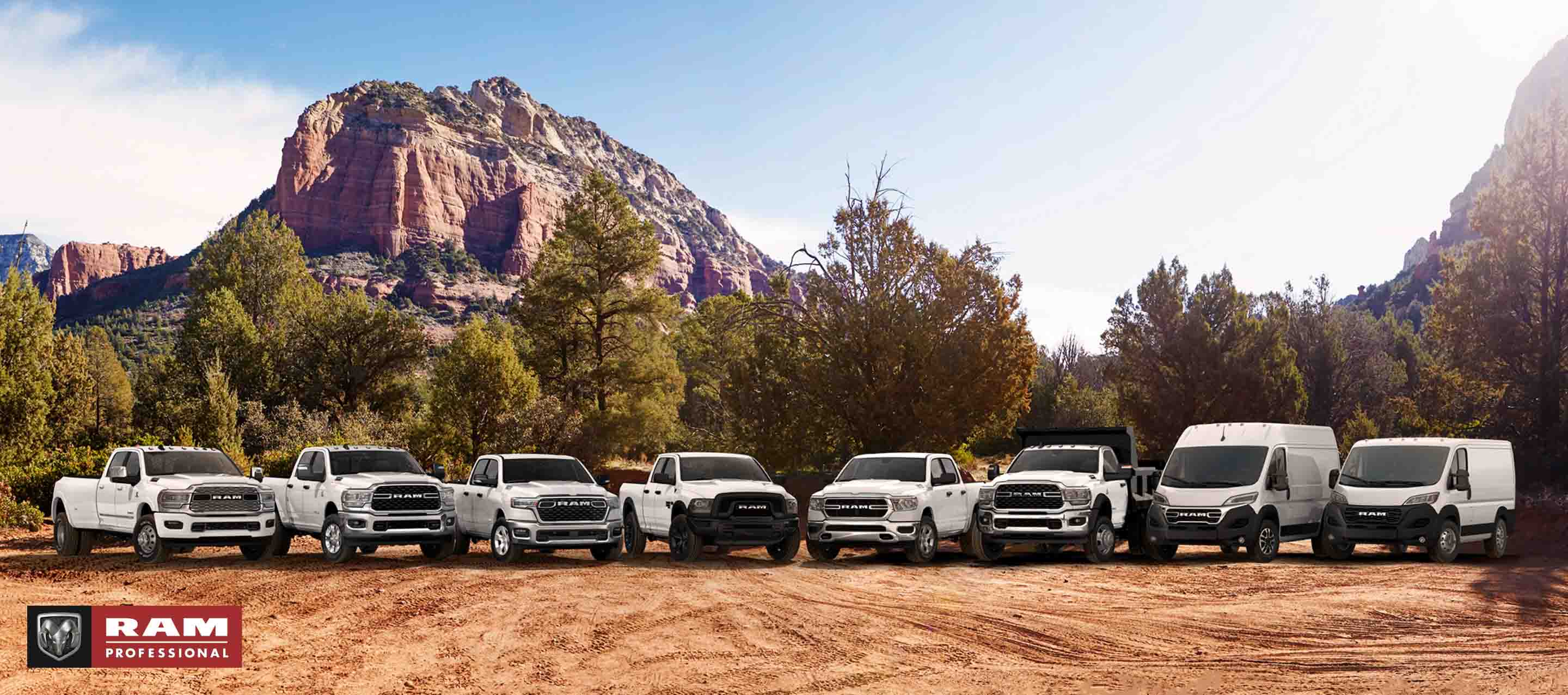 La línea de la marca Ram, toda de blanco, con los vehículos estacionados uno al lado del otro en un claro, con montañas de fondo. De izquierda a derecha: una Ram 3500 Limited Crew Cab 2024, una Ram 2500 Big Horn Crew Cab 2024, una Ram 1500 Big Horn Crew Cab 2025, una Ram 1500 Classic Warlock Quad Cab 2024, una Ram 1500 Tradesman Crew Cab 2024, una Ram 5500 Tradesman Chassis Cab Regular Cab con mejora de carrocería volcadora, una Ram ProMaster 1500 SLT+ High Roof Cargo Van 2024 y una Ram ProMaster 1500 Tradesman Standard Roof Cargo Van 2024. Ram Professional.