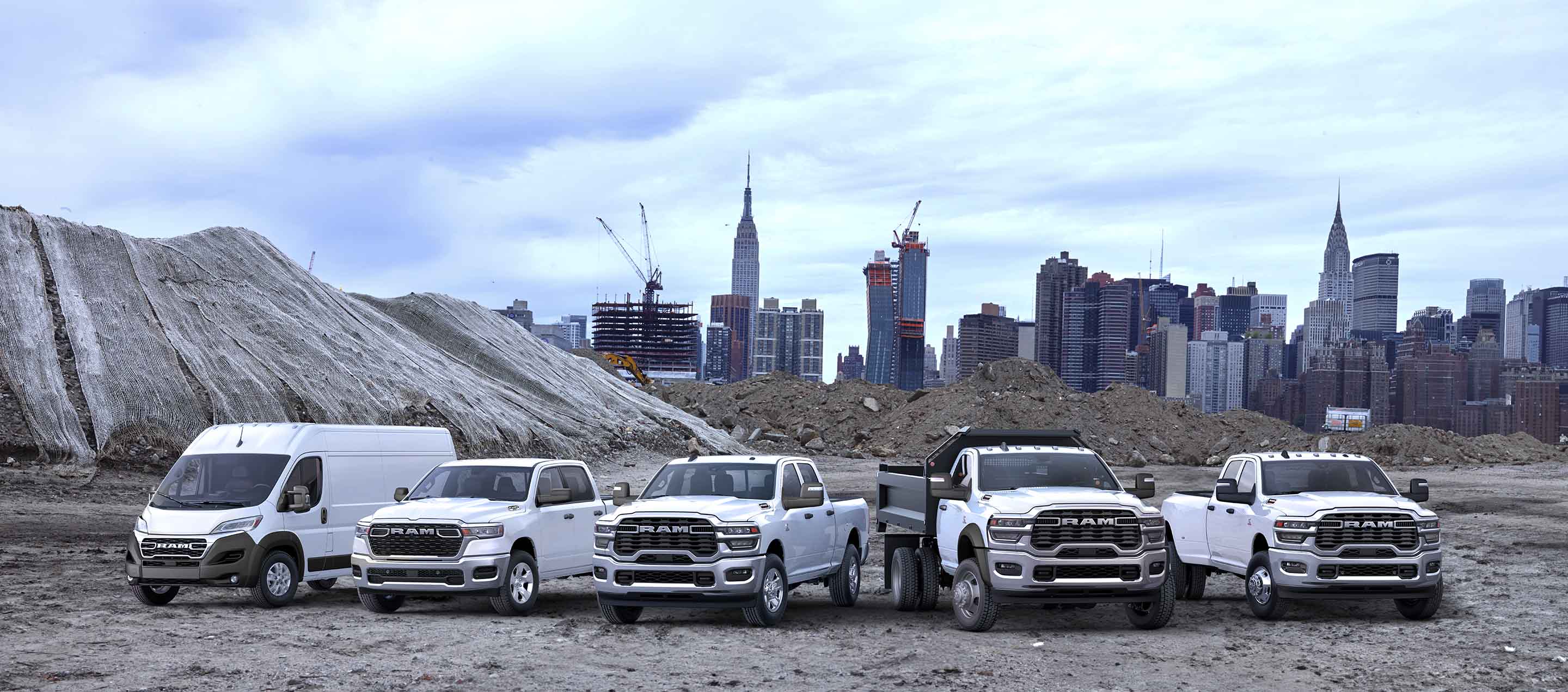 Una toma grupal que muestra una van Ram Promaster, una camioneta Ram 1500, una camioneta Ram 2500, una camioneta Ram Chassis Cab y una camioneta Ram 3500 en una obra en construcción.