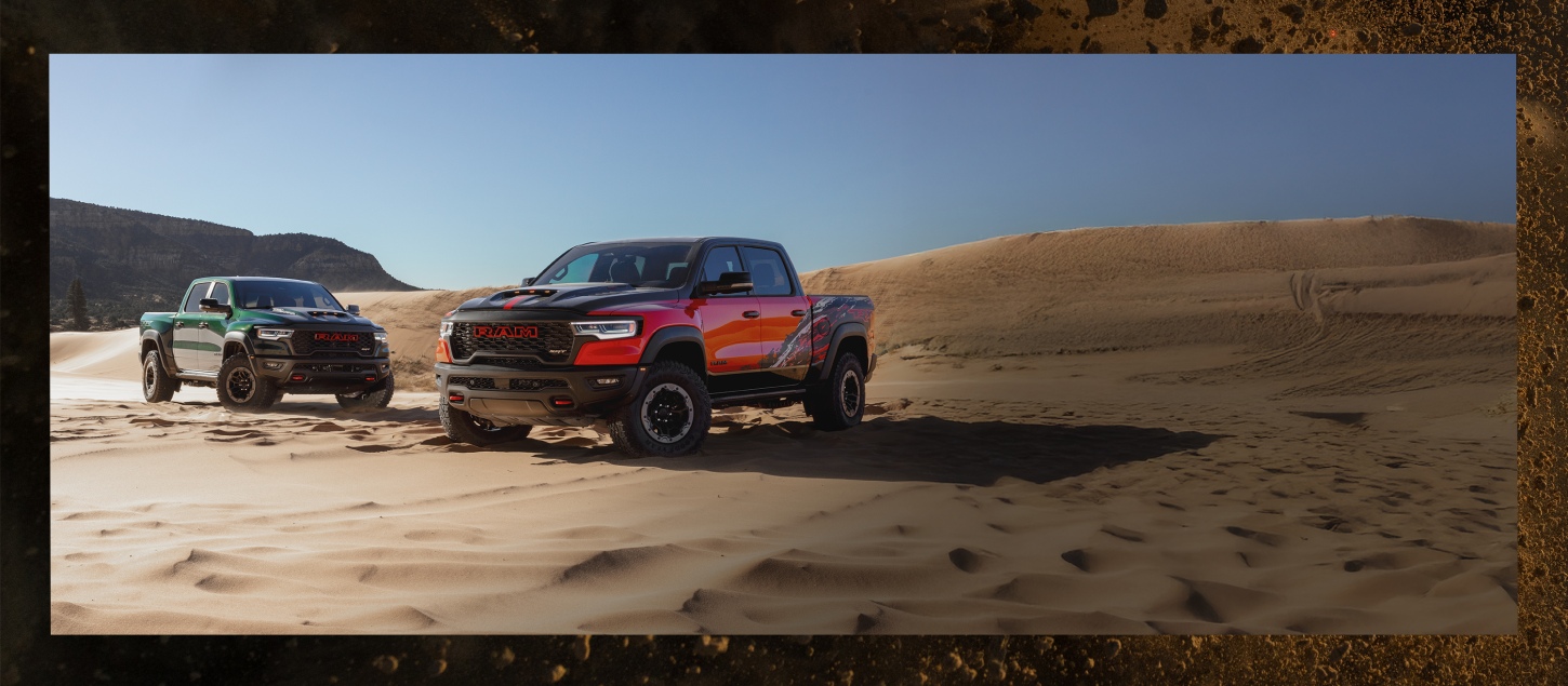 Two Ram TRX SRT pickups parked in the desert. On the left a green 2027 Ram 1500 TRX SRT 4x4 Crew Cab and on the right, a red 2027 Ram 1500 TRX SRT Bloodshot Night Edition 4x4 Crew Cab with a black hood and roof and special bedside splash graphics.