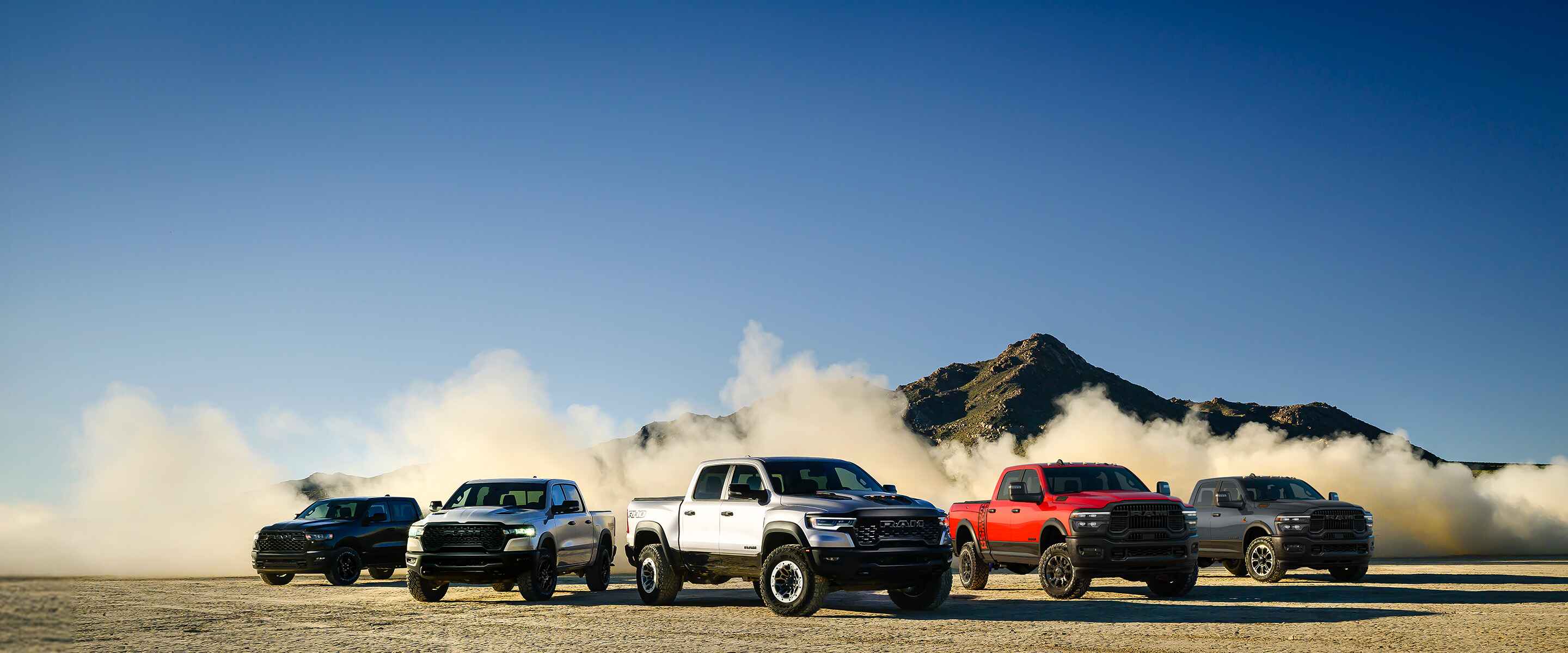 Toma de un grupo de 2025 camionetas Ram en un desierto.