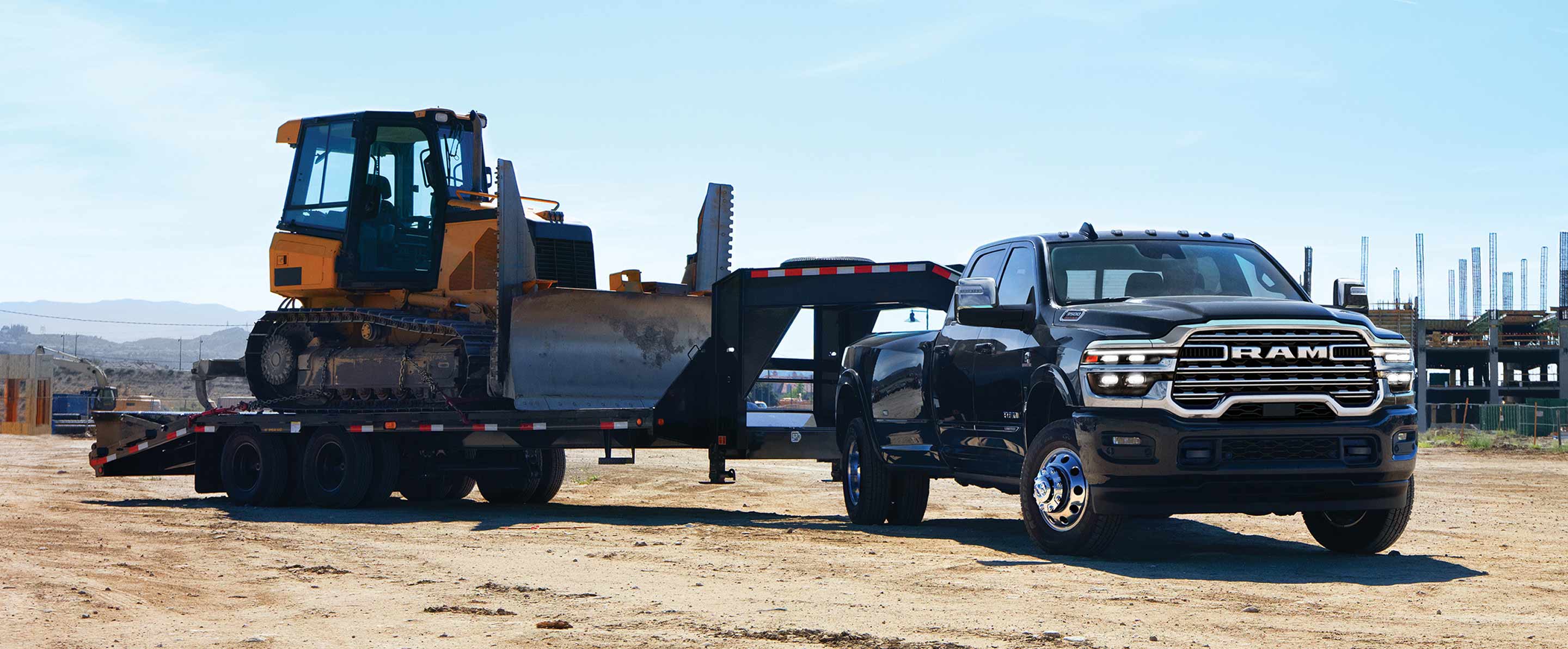 Una Ram 3500 Limited Longhorn Crew Cab 2025 negra acarreando un remolque de plataforma plana de quinta rueda, con una excavadora.